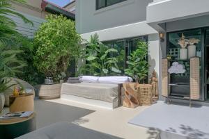 un patio con sofá y algunas plantas en SunMui Pool Villa - 7 Bedrooms - Old town, en Chiang Mai