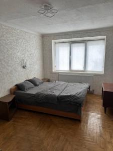 een slaapkamer met een groot bed en een raam bij 1-кімнатна квартира в центрі - Чортків in Chortkiv