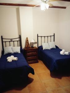 2 Betten in einem Zimmer mit blauer Bettwäsche in der Unterkunft Alojamiento Rural Casa Fuente del Prado in La Iruela + 22 Fotos
