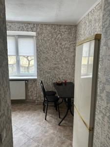 een kamer met een tafel, een stoel en een raam bij 1-кімнатна квартира в центрі - Чортків in Chortkiv