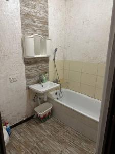 een badkamer met een wastafel en een ligbad bij 1-кімнатна квартира в центрі - Чортків in Chortkiv