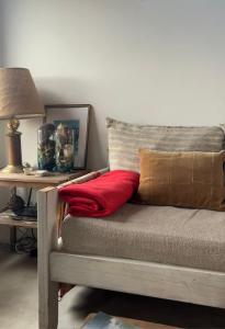 a couch with a red pillow and a lamp on a table at Lalau Casa de Playa in Chapadmalal