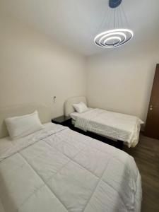 a room with two beds and a light at zayed in Sheikh Zayed