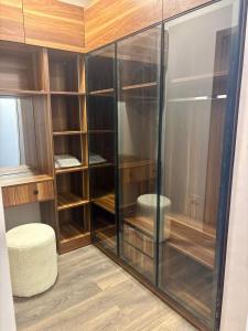 a walk in closet with glass doors and a stool at zayed in Sheikh Zayed