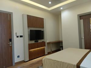 a bedroom with a bed and a flat screen tv at Hotel Shrivardhan in Sūratgarh
