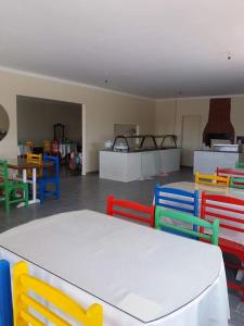 ItaberabaにあるPousada Casarraraのカラフルな椅子とテーブルが備わる客室です。
