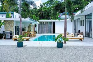 ein Haus mit Swimmingpool und Palmen in der Unterkunft Villa Modena in Las Terrenas