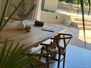 a wooden table with two chairs and a vase on it at Kokon Boutique Guesthouse in Somerset West