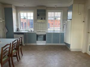 a kitchen with blue cabinets and a table and chairs at Vestergård B&B in Varde