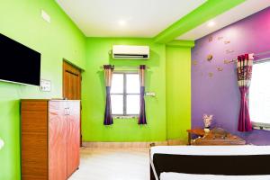 a room with green and purple walls and a tv at Hotel O A R Lodge in Durgāpur +21 photos