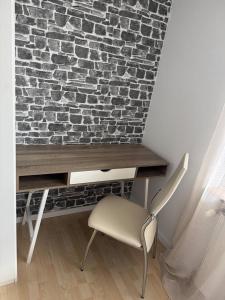 a desk with a chair next to a brick wall at 95qm Wohnung für 6, 3 Schlafzimmer, ruhig & stadtnah, Parkplatz in Bad Hersfeld +10 photos