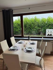 a dining room table with chairs and a large window at 95qm Wohnung für 6, 3 Schlafzimmer, ruhig & stadtnah, Parkplatz in Bad Hersfeld
