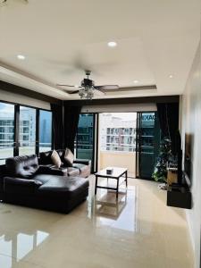 a living room with a black couch and a table at Patong Elite Condo Nanai, Patong, Phuket in Patong Beach