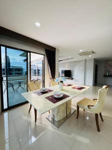 a living room with a table and chairs and a dining room at Patong Elite Condo Nanai, Patong, Phuket in Patong Beach