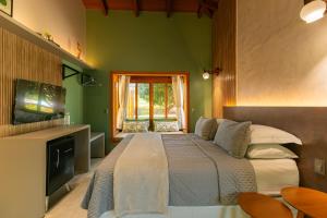 a bedroom with a large bed and a television at Pousada Solar dos Pireneus in Pirenópolis