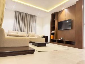 Una sala de estar con un sofá y un televisor de pantalla plana. en 1260 Lumaana Residence, en Garki 14 fotos más