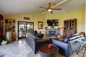 een woonkamer met lederen meubels en een open haard bij A Villa with extraordinary views in Solvang