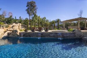 een zwembad in een tuin met een steunmuur bij A Villa with extraordinary views in Solvang