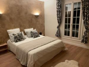 une chambre avec un lit avec des oreillers et une fenêtre dans l'établissement Domaine des Tuilières avec piscine, à Vallauris
