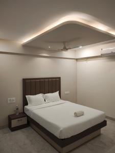 a bedroom with a large white bed in a room at Hotel RRR in Bhor