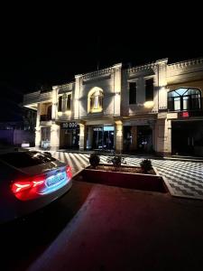 a car parked in front of a building at night at Old Saroy Hotel in Samarkand