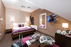 Habitación de hotel con cama y escritorio con sidra de mesa en Hotel Fürdőház, en Nyíregyháza