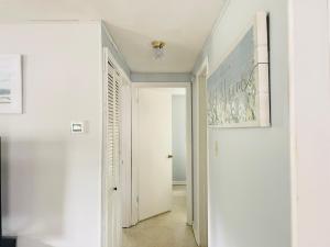 un pasillo con paredes blancas y una puerta blanca en Chazzdoorway 2rooms 1 bathroom Duplex, en Homosassa