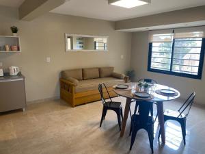 a living room with a table and chairs and a couch at Complejo Médanos II in San Bernardo