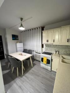にあるKleas apartmentのテーブル付きのキッチンと白いキャビネット付きのキッチン