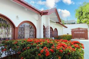 a white building with red flowers in front of it at O'Reilly's Bungalow in Negombo