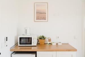 a kitchen with a counter with a microwave on it at Villa Paraíso da Caparica in Charneca +52 photos