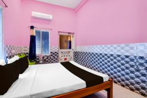 a bed in a room with pink walls at OYO Flagship Hotel O Mo Kudia in Puri