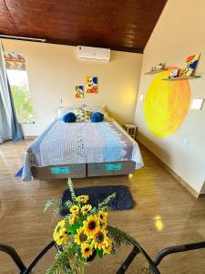 a bedroom with a bed with sunflowers on it at Chalé Sun Happy in Serra de São Bento