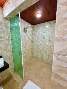 a bathroom with a shower with a glass door at Chalé Sun Happy in Serra de São Bento +29 photos