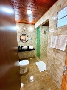 a bathroom with a toilet and a glass shower at Chalé Sun Happy in Serra de São Bento