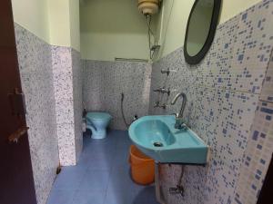 a bathroom with a blue sink and a toilet at Hotel O Sun View in Gangtok