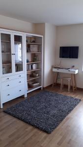 a living room with a white cabinet and a desk at Grand T2 Côte de granit rose plages et commerces à proximité in Trégastel