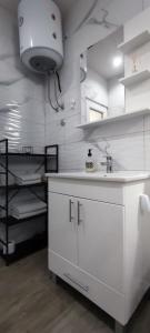 Dubrave GornjeにあるApartments Airport Innのキッチン(白いカウンター、シンク付)