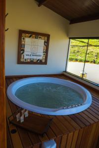 a jacuzzi tub in a house with a window at Chalé Vale Paraíso in Paraisópolis +95 photos