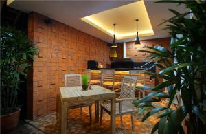 a dining table and chairs in a room with a brick wall at Sleepwell Seminyak in Seminyak