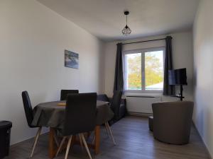フラにあるAppartement T3 idéalement situéのテーブルと椅子と窓のあるダイニングルーム