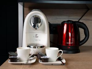 a coffee maker and two cups on a table at Apartamenty 3 Maja in Płock