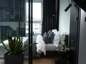 a bedroom with a bed with white pillows and a window at Apartamenty 3 Maja in Płock