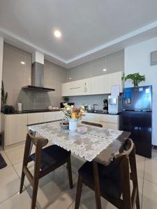 a kitchen with a table with chairs and a black refrigerator at Jenz Homestay Bintulu in Bintulu