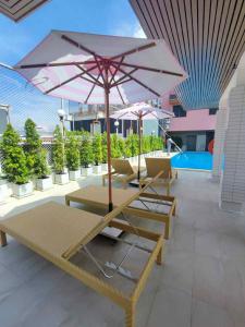 a group of lounge chairs and an umbrella on a roof at Cloudotel Walking Street Pattaya in Pattaya