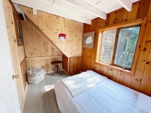 une chambre avec un lit dans une pièce en bois dans l'établissement Boardwalk Pines at Tobermory, à Tobermory