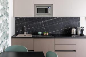 a kitchen with white cabinets and a microwave at Somma Relax Apartment in Sommacampagna