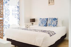 a bedroom with a large bed with blue and white pillows at Villa Paraíso da Caparica in Charneca