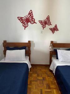 a room with two beds with butterflies on the wall at Fazenda Brasileiro in Passos