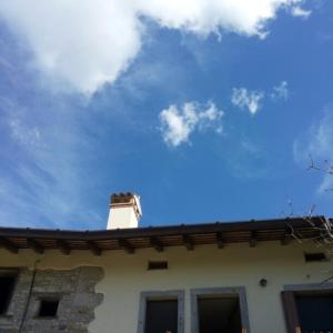un techo de una casa con chimenea y un cielo azul en Alloggi Valle di Soffumbergo, en Valle